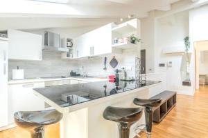 a kitchen with a counter and two stools at [Penthouse] Piazza San Giacomo in Udine