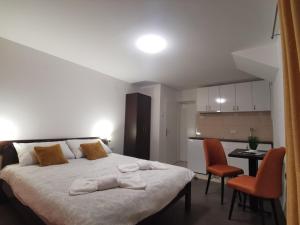 a bedroom with a bed and a table and chairs at Apartmani Ostojic in Vrdnik