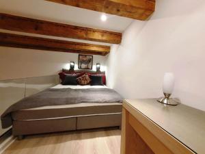 ein Schlafzimmer mit einem Bett in einem Zimmer mit Holzdecken in der Unterkunft Mezzanine de Grinzing in Wien