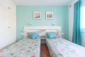 2 camas en una habitación con paredes azules en Private villa with heated pool & terrace see view, en Corralejo