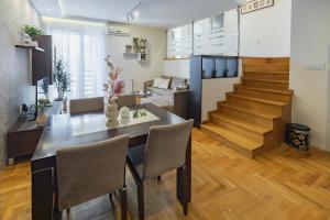 uma cozinha e sala de jantar com uma mesa de jantar e escadas em Apartment Simpatico em Novi Sad