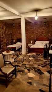 a room with two beds and a stone wall at Fazenda Hotel Bem Ecológico in Planaltina