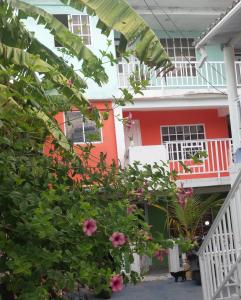 una casa roja y blanca con flores rosas en Posada J&J Forbes - 2, en San Andrés