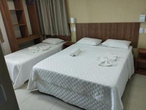 two beds in a hotel room with towels on them at Pousada Casarão do Porto - Porto de Galinhas PE in Porto De Galinhas
