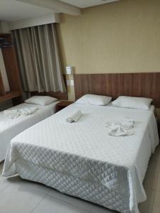 a hotel room with two beds with white sheets at Pousada Casarão do Porto - Porto de Galinhas PE in Porto De Galinhas