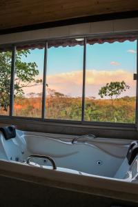 a bath tub with a view of the savannah at Fazenda Hotel Bem Ecológico in Planaltina