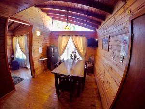 - une salle à manger avec une table dans une maison en bois dans l'établissement CABAÑAS AIRES DE MAROMILLAS, à Constitución