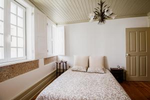 a bedroom with a bed with two pillows and a window at Casa da Judiaria Velha in Viseu