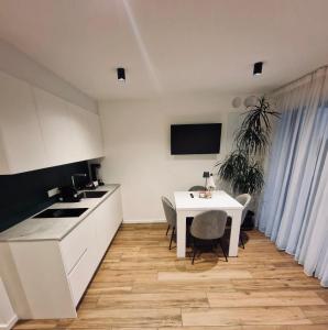 cocina con mesa blanca, mesa y sillas en M&M-Apartment en Brunico