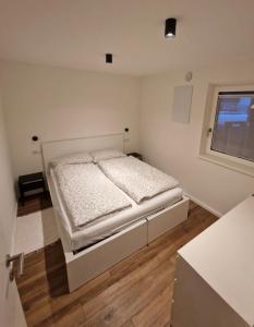 1 dormitorio con 1 cama blanca y ventana en M&M-Apartment en Brunico