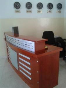 a wooden desk in an office with plates on the wall at Al Basateen Hotel Apartment in Sur