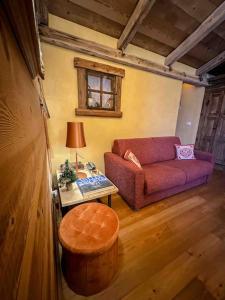 een woonkamer met een paarse bank en een tafel bij La Buca delle Fate in Gressan