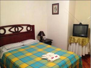 1 dormitorio con 1 cama con 2 toallas en Hostal Jora Continental, en Cotacachi