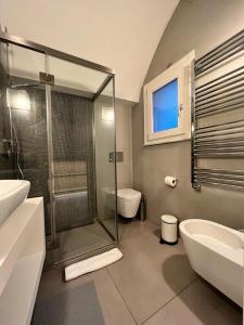 uma casa de banho com um chuveiro, um lavatório e um WC. em La Suite di Piazza dell'Università em Catânia
