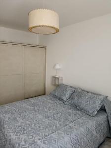 1 dormitorio con 1 cama con edredón gris en Alquiler turístico de casa en San Rafael en San Rafael