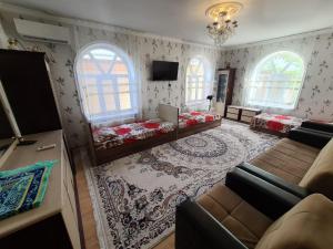 Gabala red house في غابالا: غرفة معيشة بها سريرين وأريكة