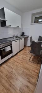 a kitchen with a stove and a table and a chair at Waterfalls Apartment 1 in Triberg
