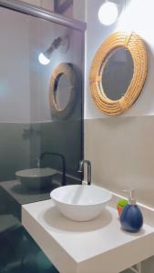 baño con lavabo blanco y 2 espejos en Copacabana Beach! Aconchegante apartamento na quadra da praia., en Río de Janeiro