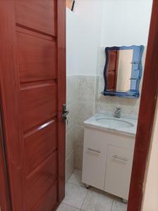 a bathroom with a sink and a wooden door at Hotel Apartamentos "Dominó" in Tarija