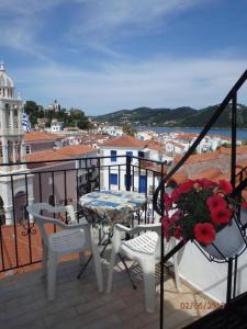 a balcony with a table and chairs and a view of a city at nostalgo in Skiathos Town