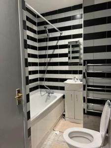 baño con pared de rayas en blanco y negro en 1 Bedroom flat in Euston! 4 person. en Londres