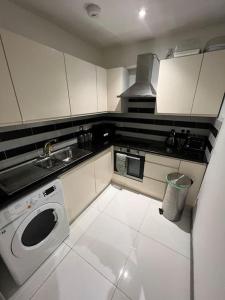 cocina con fregadero y lavadora en 1 Bedroom flat in Euston! 4 person. en Londres
