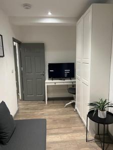 sala de estar con TV y escritorio con ordenador en 1 Bedroom flat in Euston! 4 person. en Londres