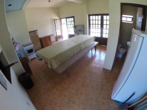 a bedroom with a large bed in a room at Suítes Casa Amarela da Ferrugem in Garopaba
