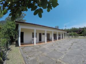 a white building with a lot of windows at Suítes Casa Amarela da Ferrugem in Garopaba