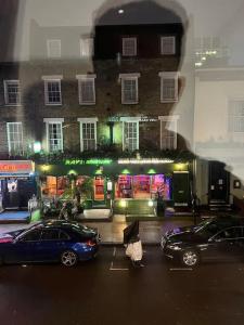 dos autos estacionados en un estacionamiento frente a un edificio en 1 Bedroom flat in Euston! 4 person. en Londres