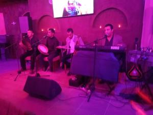 un grupo de hombres tocando instrumentos en una habitación en Palais D'Ouzoud, en Azilal