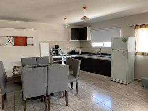 a kitchen with a table and chairs and a white refrigerator at Casa de Ali in Villa Carlos Paz