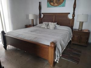 a bedroom with a wooden bed with two night stands at Aventura Pacifico Boutique Hotel in Bucerías