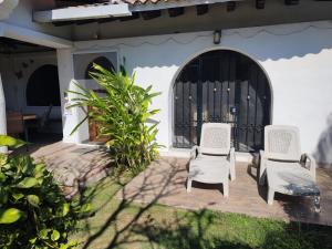 two white chairs sitting on a patio in front of a house at Aventura Pacifico Boutique Hotel in Bucerías