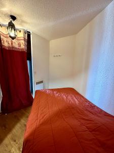 a bedroom with a bed with a red blanket at LE MONTAGNARD in Isola 2000