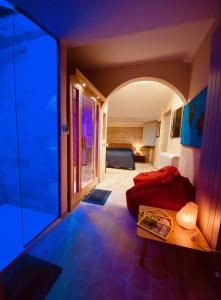 Vermaaten Boutique Suites Diamond في تودي: غرفة معيشة بسرير احمر وباب زجاجي