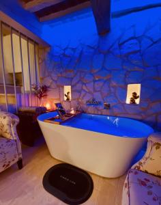 a bath tub in a room with a stone wall at Vermaaten Boutique Suites Diamond in Todi