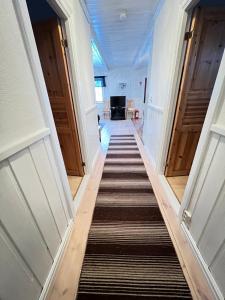 um corredor com uma longa escadaria com portas de madeira em Norra Brändan em Sälen