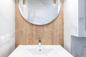 a bathroom with a white sink and a mirror at Les Cocons Heritage in Lyon