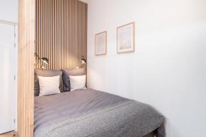 a bedroom with a bed with a wooden headboard at Les Cocons Heritage in Lyon
