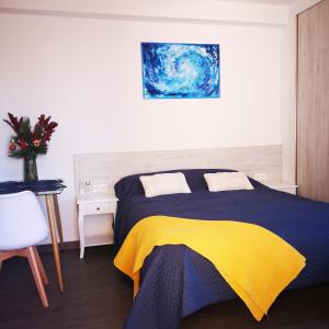 a bedroom with a bed with a yellow and blue blanket at Sunny studio La Mata beach in Torrevieja
