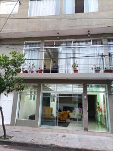 a building with glass doors and a balcony at Hotel Apartamentos "Dominó" in Tarija