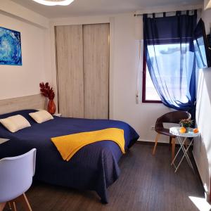 a bedroom with a blue bed with a yellow blanket at Sunny studio La Mata beach in Torrevieja