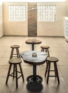 Central Praias Suite 1 في كابو فريو: طاولة وأربع كراسي في غرفة