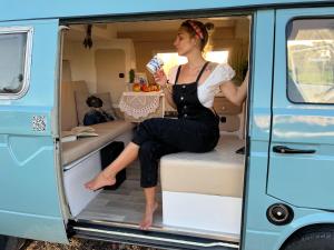 a woman sitting in the back of a van at Rent a BlueClassics 's campervan vw T3 azulina in Algarve au Portugal, in Portimão