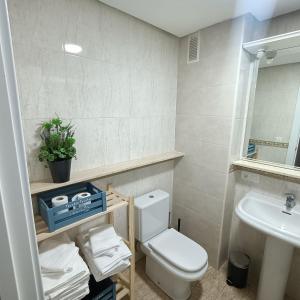 uma casa de banho com um WC branco e um lavatório. em Luxury Family Homes M em Salamanca