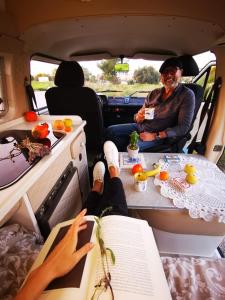 Ein Mann, der hinten im Van sitzt und einen Tisch hat. in der Unterkunft Rent a BlueClassics 's campervan vw T3 in Algarve au Portugal, in Portimão