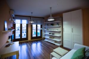 een woonkamer met houten vloeren en witte kasten bij Apartamentos Suites&Homes in Salamanca