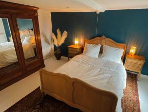 una camera con un letto con due lampade e uno specchio di Au détour du vieux hêtre ad Aywaille