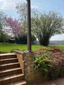 una escalera con un poste junto a un jardín con flores en Au détour du vieux hêtre, en Aywaille